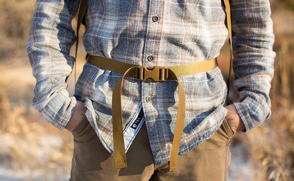 A close shot of a person using the included hip belt of the Guide's Edition Synapse 25.